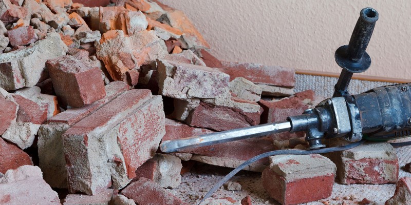 Abbrucharbeiten: Zerstörte Ziegelsteine mit Stemmhammer auf dem Boden