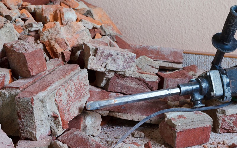 Abbrucharbeiten: Zerstörte Ziegelsteine mit Stemmhammer auf dem Boden